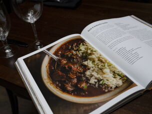 A page from Peter Harris and Brian Landry's cookbook, <em>Rhythm & Roux: The Simmer and Swing of New Orleans</em> lays on display at Bayou Bar.