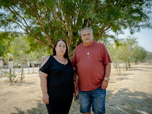 Meir and Kati Zohar hold hands as they pose for a portrait beneath a tree at the Nova music festival memorial site in southern Israel on Sept. 24, 2026. Their daughter, Bar Zohar, was killed during the Hamas-led assault on the festival on Oct. 7, 2023.