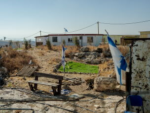 An Israeli flag erected by settlers is seen through the window of the home of Ikhlas al-Hathaleen in the Palestinian village of Umm al-Kheir, in the Masafer Yatta region of the Israeli-occupied West Bank, on Sept. 24, 2026. Israeli military closure orders have restricted the Palestinian family from accessing their courtyard toilet and sheep pen.