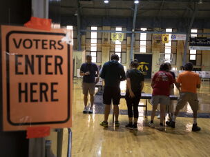Voters go to the polls to cast their ballots in the Michigan primary election on Tuesday in Lansing Mich.