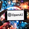 FILE - The OpenAI logo is displayed on a cell phone in front of an image generated by ChatGPT's Dall-E text-to-image model, Dec. 8, 2023, in Boston.