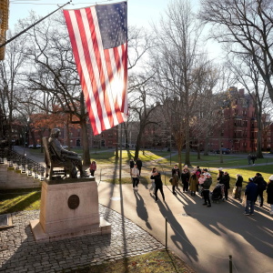 FILE - People take photos near a John Harvard statue, left, on the Harvard University campus, Jan. 2, 2024, in Cambridge, Mass.