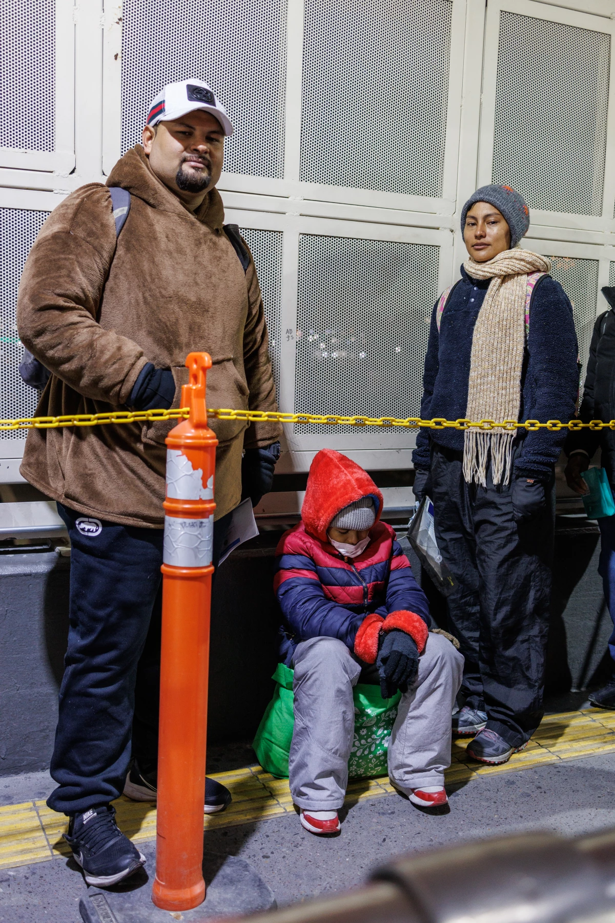 Hondurans David Melgar, 28, his wife Gabriela Maradiaga, 26 and their son Tailer Melgar, 8, wait atop the Paso del Norte Bridge to be allowed into the United States for their CBP One appointment.