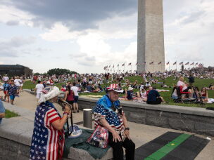 People sit near the Washington Monument ahead of the