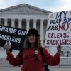 Grace Bisch holds a picture of her stepson Eddie Bisch, who died from an overdose, while protesting during oral arguments Dec. 4 at the Supreme Court in Washington, D.C. The Supreme Court's ruling on June 26 upended a proposed nationwide settlement with Purdue Pharma, the manufacturer of OxyContin. Members of the Sackler family, who owned the company, will have to negotiate a new settlement for lawsuits over the impact of opioids.