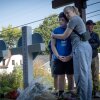 Community members visit a memorial for shooting victims in front of Annunciation Catholic Church in Minneapolis, one day after a shooter opened fire on students and parishioners during a Catholic school Mass.
