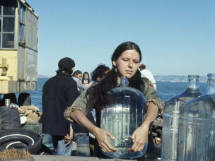 A young woman sets up large bottles of drinking water on Alcatraz Island on Nov. 17, 1970. This was part of a 19-month-long occupation by Native American activists in protest of U.S. government policies on treaties.