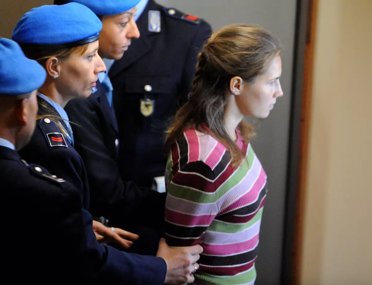 Amanda Knox surrounded by Italian police in 2008, when she was a suspect in Meredith Kercher's murder.