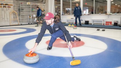 Ted Hallock delivers a rock during a curling game at the Potomac Curling Club in Laurel, Md. Curling clubs often see a boost in interest following the Winter Olympics.