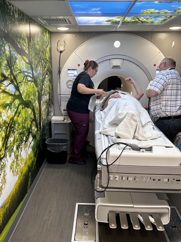 MRI technician Helen Cryan gets Retta Jacobi ready for her scan inside a mobile imaging semitrailer at Southwest Healthcare Services in Bowman, North Dakota, with the help of the truck’s driver, Kevin Kraft, who also works as a medical assistant.