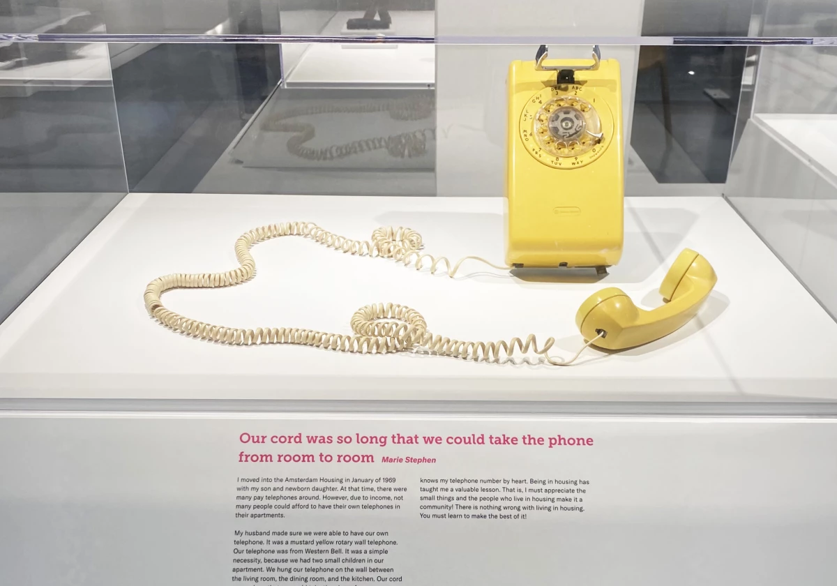 Yellow rotary dial phone, pictured in the 'History Lessons' exhibition, a collection of objects on loan from current or former housing residents, who also wrote the labels.