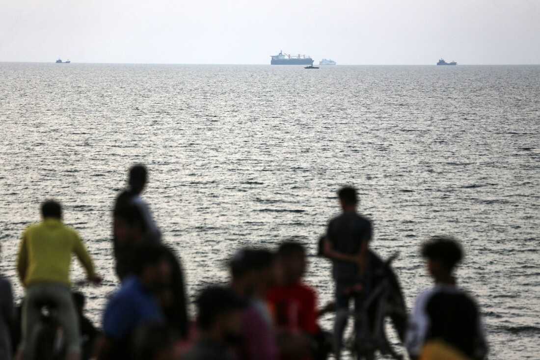 Palestinians are gathering in the hope of obtaining aid delivered into Gaza through a U.S.-built pier, amid the ongoing conflict between Israel and the Palestinian Islamist group Hamas, as seen from central Gaza Strip, on May 19, 2024.