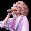 How Dolly Parton wrote the story of a changing America : NPR 15 Dolly Parton sings into a microphone that she's holding.