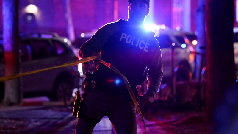Image 32: A police officer hangs yellow crime tape at Brown University in Providence, R.I., on Dec. 13, 2025, during the investigation of a shooting.