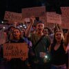 People chant while holding banners during a protest against a law targeting anti-corruption institutions in central Kyiv, Ukraine on Tuesday.