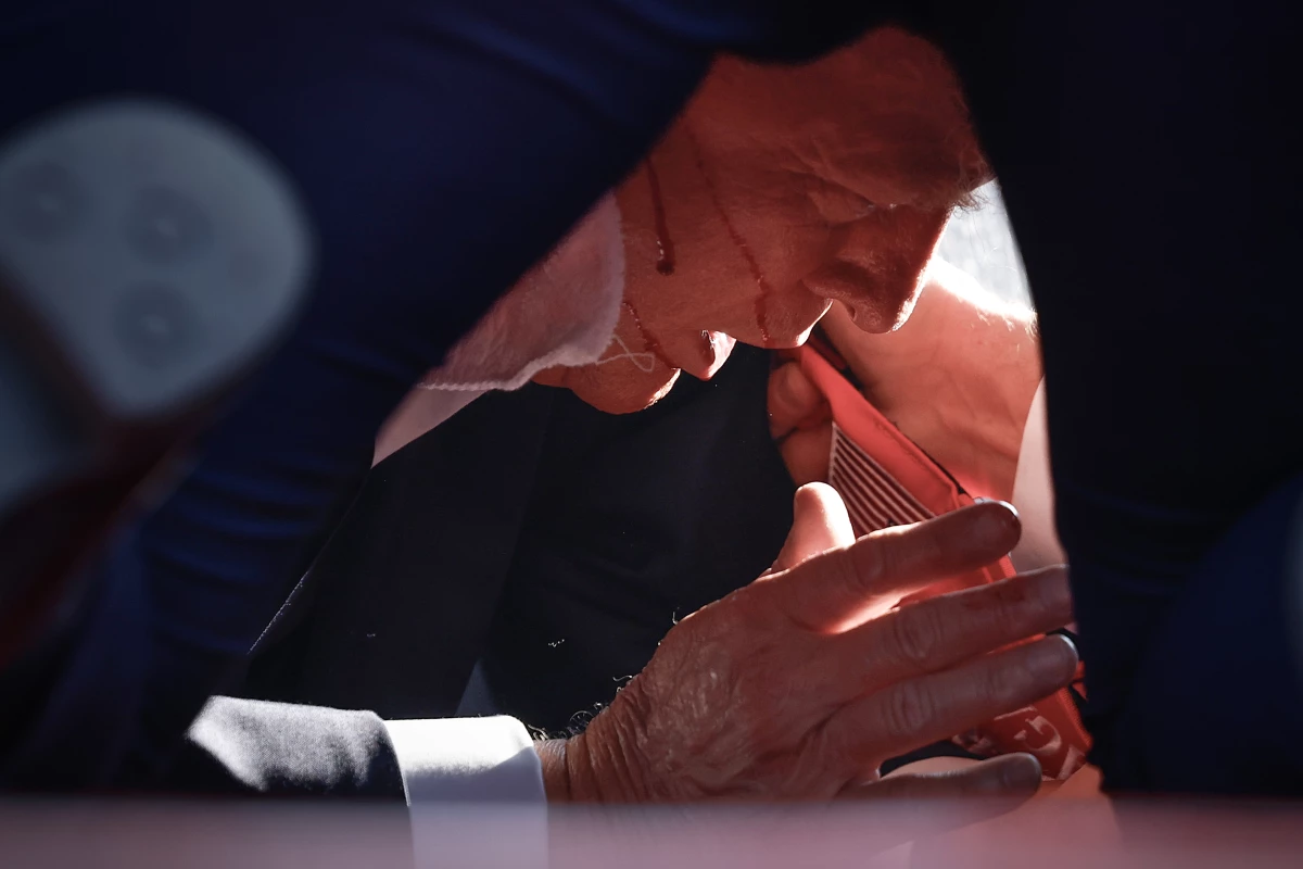Republican presidential candidate former President Trump is shown covered by U.S. Secret Service agents after an incident.