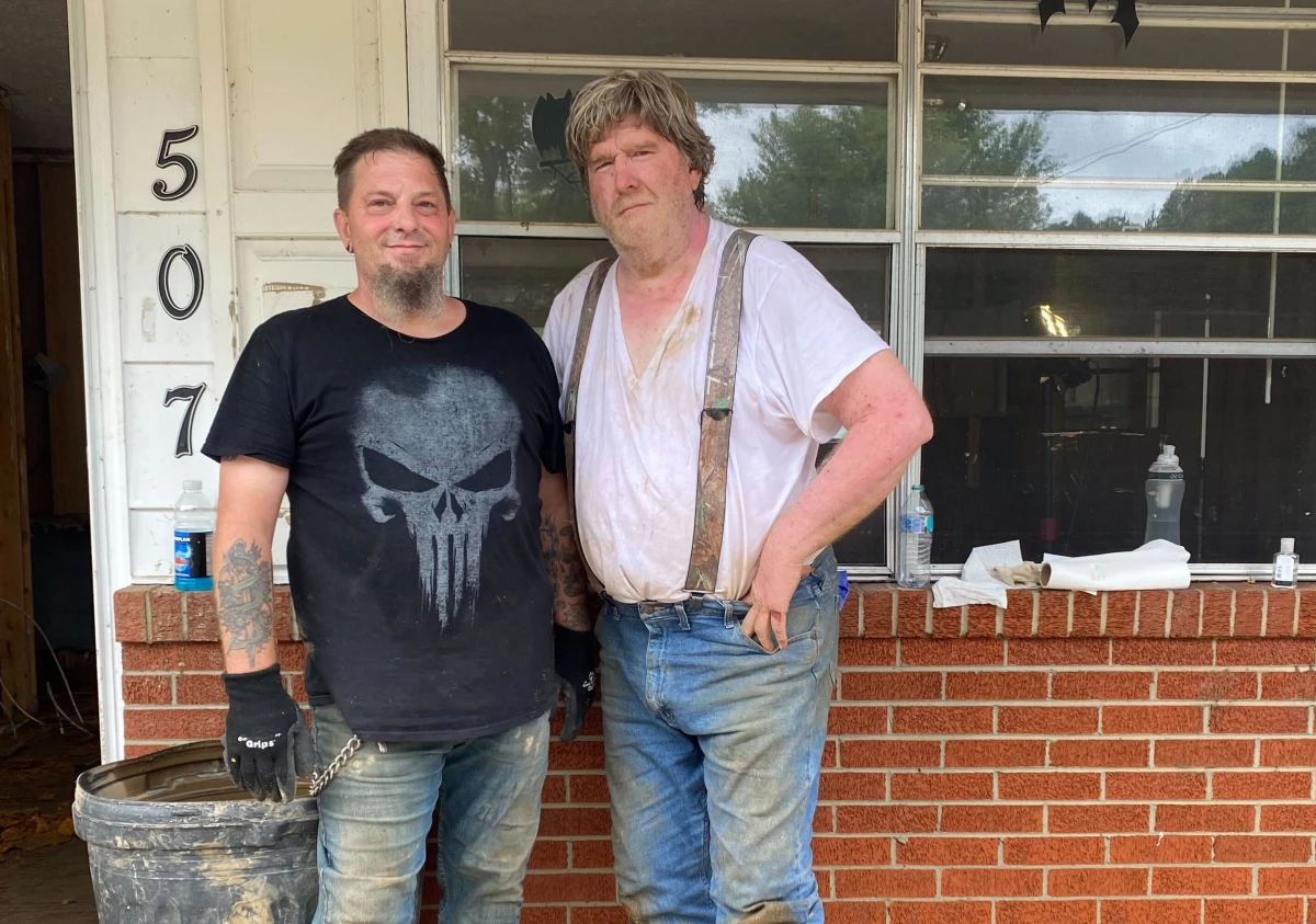 Don Reeb (right) and his friend Richard Greenlaw in front of Reeb's home. They've been clearing it out, with help from volunteers, after it took on five feet of water.