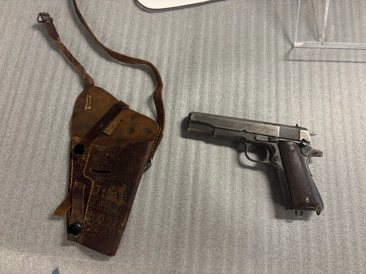 The .45-caliber pistol used to kill Emmett Till is shown with the gun's holster and the initials 'J M' carved into the leather. The gun belonged to J.W. Milam. Curator Nan Prince says it was Milam's military service weapon from 1945.
