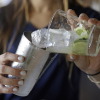 Bartender Rafaella Demelo adds sugar, 1.5 ounces of Leblon, and half a lime over ice in a shaker while preparing a caipirinha, Brazil’s trademark cocktail.