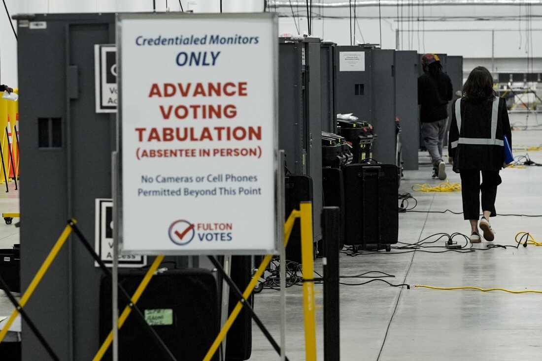 An election worker walks near voting machines at the Fulton County Election Hub and Operation Center on Nov. 5, 2024.