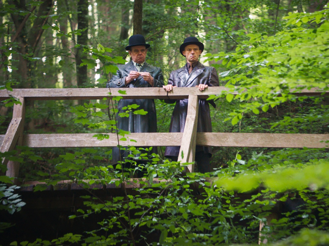 Two men in leather coats (Raimund Wallisch, left, and Gerhard Liebmann) lurk in the background, a representation of the angst and absurdities of bureaucracy that concerned Kafka.