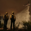 A helicopter drops water on Mandeville Canyon as the Palisades Fire rages Saturday in Los Angeles.
