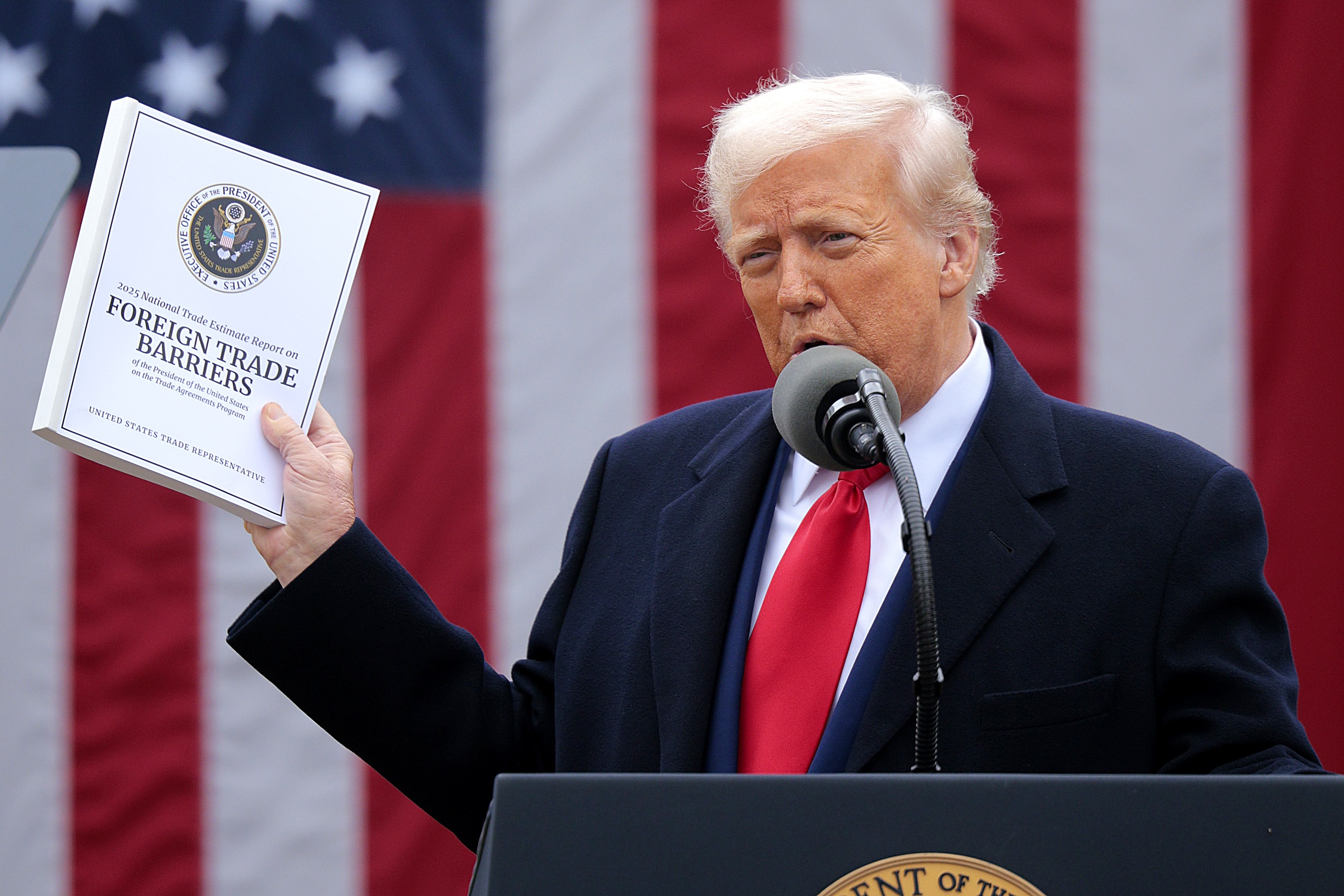 President Trump holds up a report outlining foreign trade barriers while announcing steep tariffs on April 2.