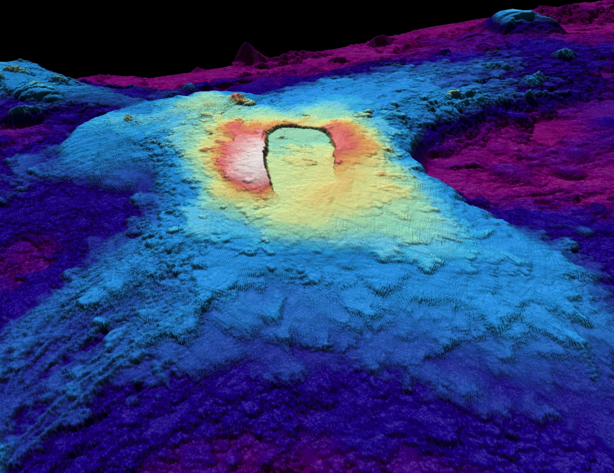 A three-dimensional map of the seabed shows the shape of the caldera of the Axial Seamount volcano. Warm colors show shallower depths and cool colors are deeper.