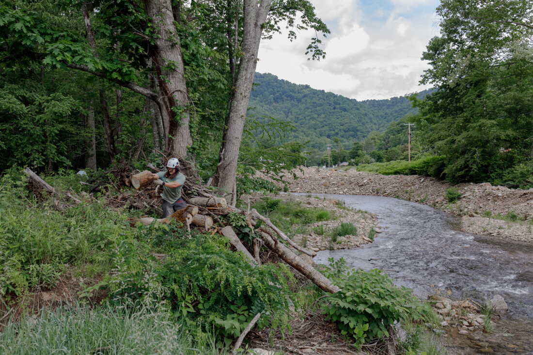 Kyle Cresap clears debris tangled in fallen logs outside of Burnsville, N.C. in May 2026.