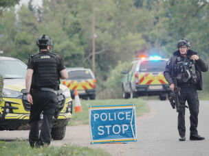 Police stand at a road block on the road to RAF Fairford after an incident, in Whelford, England, Sunday, Sept. 27, 2026,