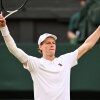 Italy's Jannik Sinner raises his arms and racket in celebration of his victory against Spain's Carlos Alcaraz at Wimbledon, southwest London, on Sunday. Sinner is wearing a white shirt and hat.