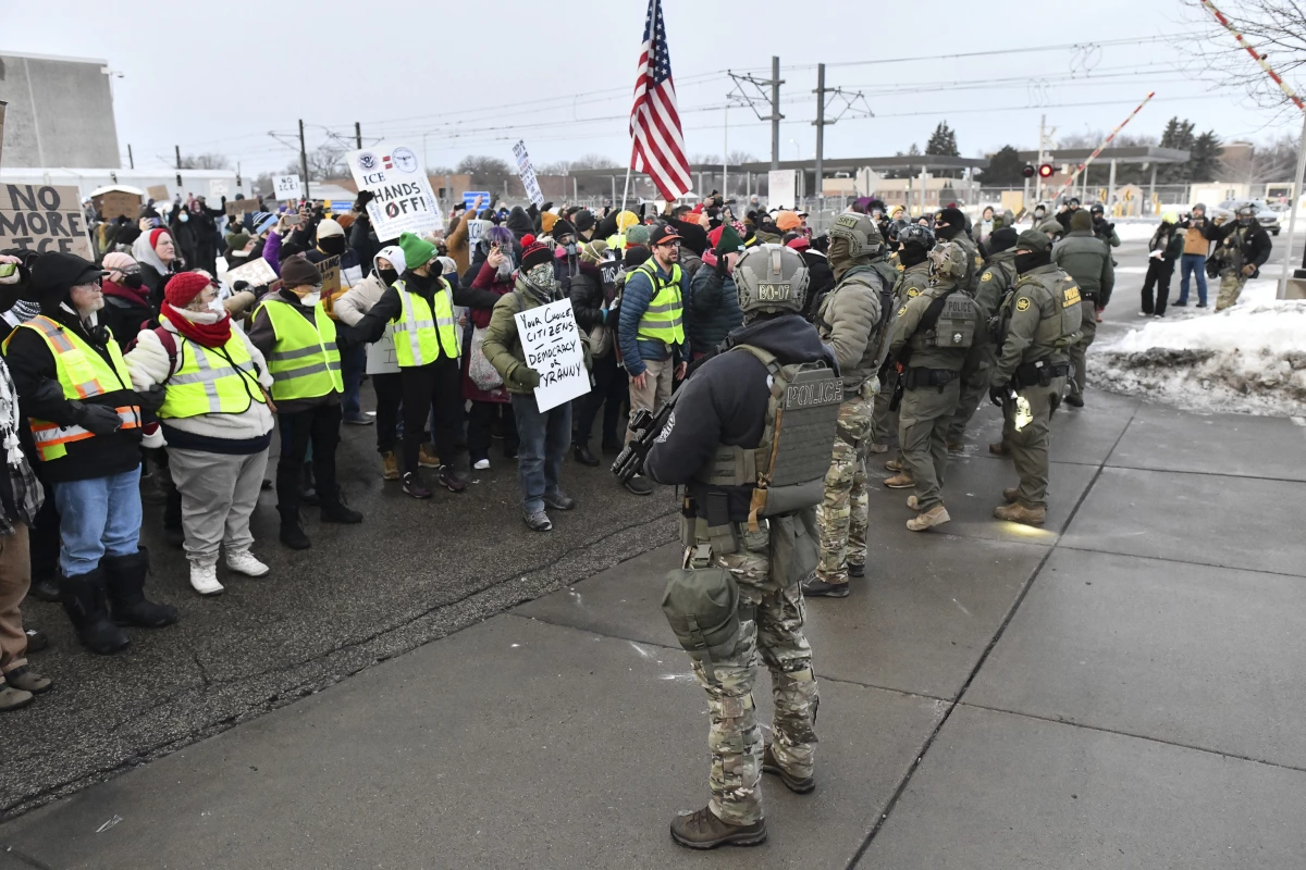 Federal agents stand watch as protestors gather outside the Bishop Henry Whipple Federal Building near Minneapolis, on Thursday.