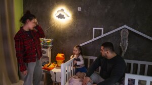 Hanna and Arkadii Rubin try to convince their daughter Leya, 2, to go to bed although she doesn't want to. They live in an apartment in Kharkiv where, just over a year ago, part of the building was damaged in a missile attack.
