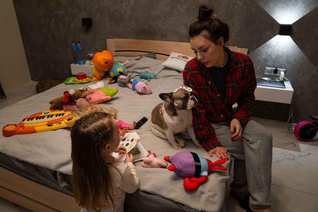 Hanna and her daughter Leya with their dog. Hanna says their dog shows the most fear when they hear explosions outside, shaking and sometimes urinating on the floor.