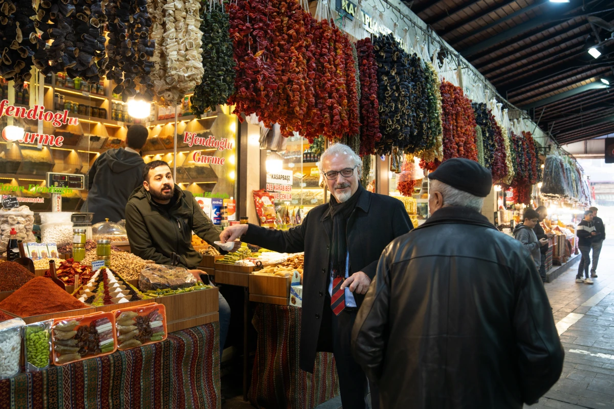 Mustafa Bayram (center), a professor of food engineering at Gaziantep University, walks through the Elmaci bazaar in Gaziantep, looking at and talking about the different foods and ingredients for sale.