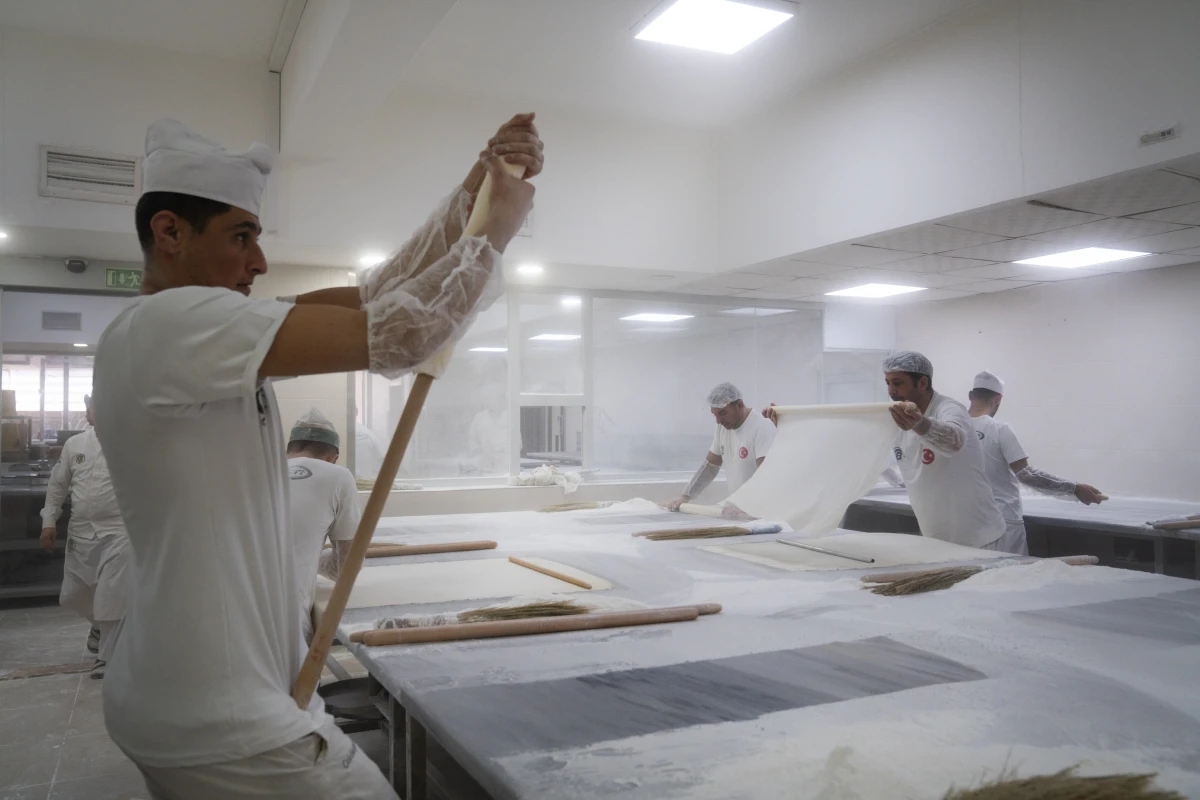 Bakers roll and stretch dough into paper-thin sheets for baklava at the factory of Celebiogullari.