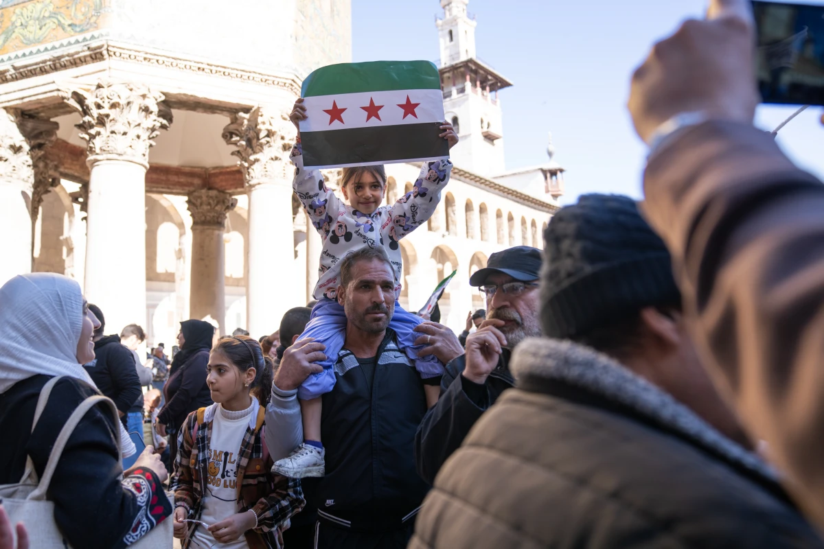 A child holds the new Syrian flag at the Umayyad Mosque on Friday.