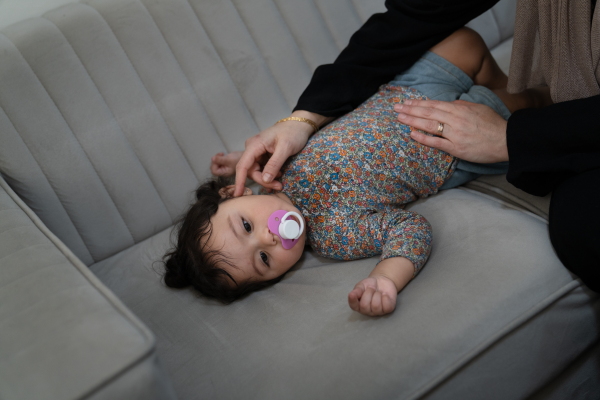 Soha Sakallah tries to coax her granddaughter, Mariam, to sleep on the sofa.