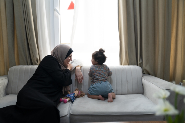 Soha Sakallah plays with her granddaughter, Mariam, at an apartment complex for refugees from Gaza in Doha, Qatar, in September soon after they arrived to the country from Egypt.