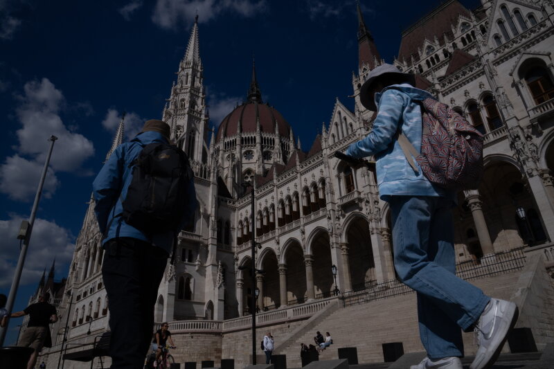 People walk past Hungary's parliament building in Budapest.