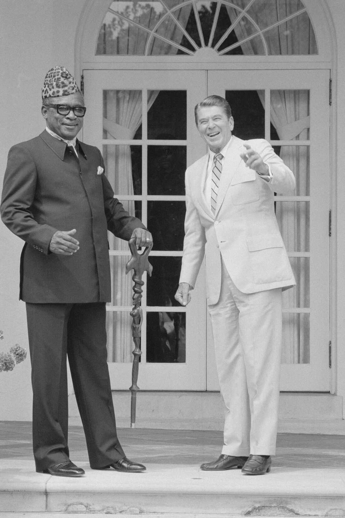 President of Zaire, Mobutu Sese Seko, holding his walking stick, and President Reagan pose for photographers in the rose garden before a meeting at the White House, Aug.4th. 1983.