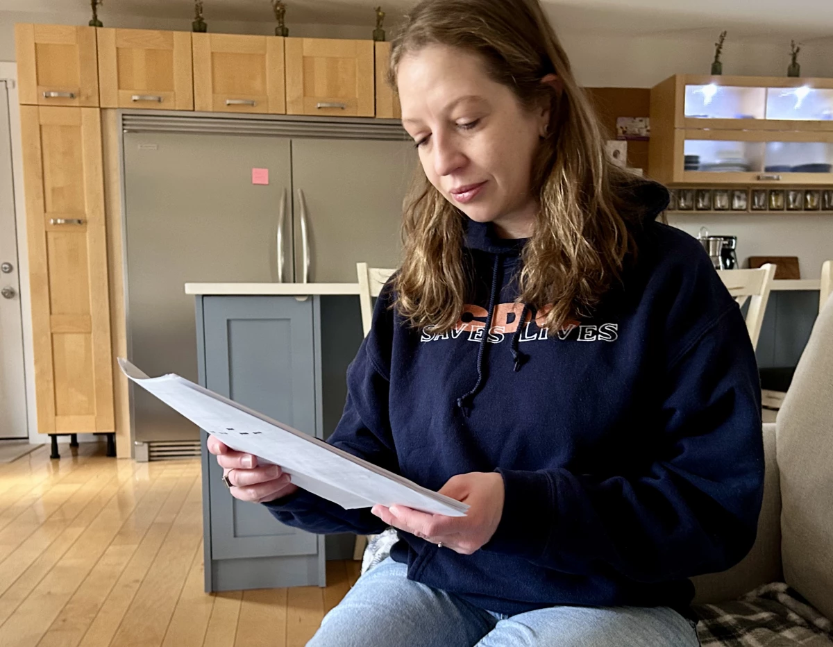 Former CDC employee Sarah Boim re-reads the termination letter, at her home in Atlanta. Boim lost her job in the first big round of firings in mid-February, 2025, just weeks into the second Trump administration.
