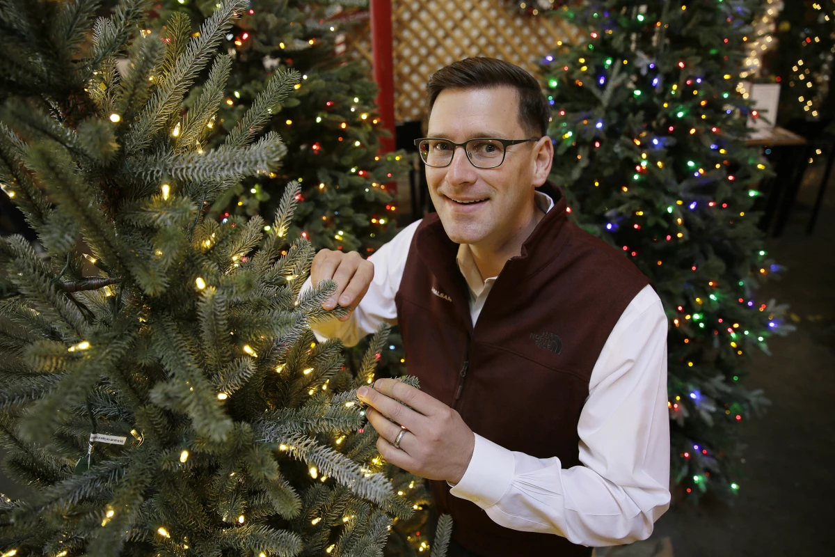 In this photo, Balsam Brands founder and CEO Mac Harman poses with artificial Christmas trees at the Balsam Hill Outlet store in Burlingame, Calif.