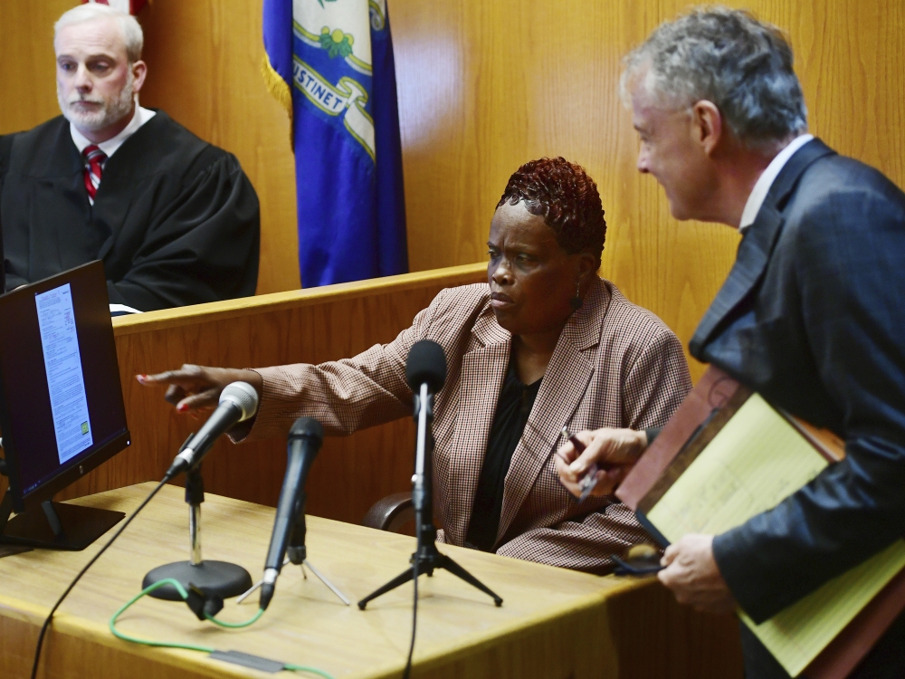 Wanda Geter-Pataky (center) talks with her lawyer, John Gulash (right), during October 2023 testimony in a challenge of absentee ballots in the 2023 Bridgeport, Conn., mayoral Democratic primary. Geter-Pataky was among four people charged Tuesday in relation to the city's 2019 mayoral primary. (Hearst Connecticut Media via AP/Pool)