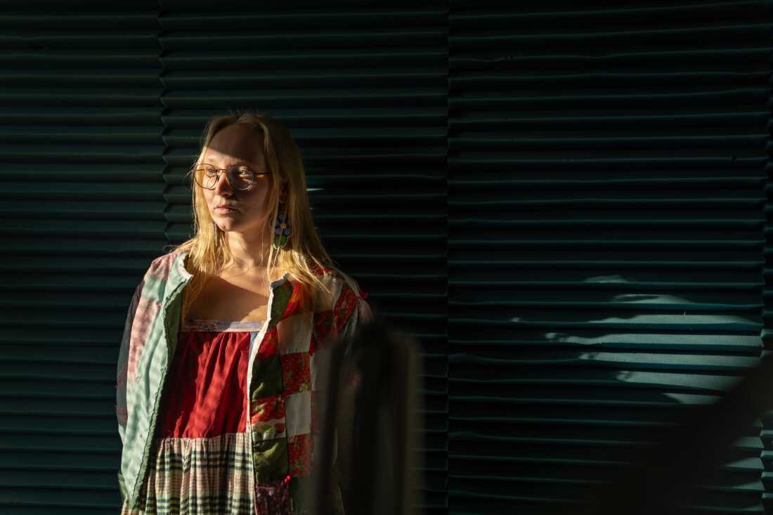 Sage Smiley, KYUK news director, stands in the office in Bethel.