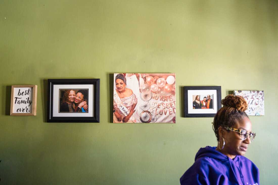 Family photos adorn the wall of Joan's bedroom. The center image is from her 70th birthday five years ago.