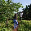 Meridah Nandudu, 35, walks up a dirt pathway that cuts through an area with lush greenery as she goes to meet with some of the farmers she buys coffee from.