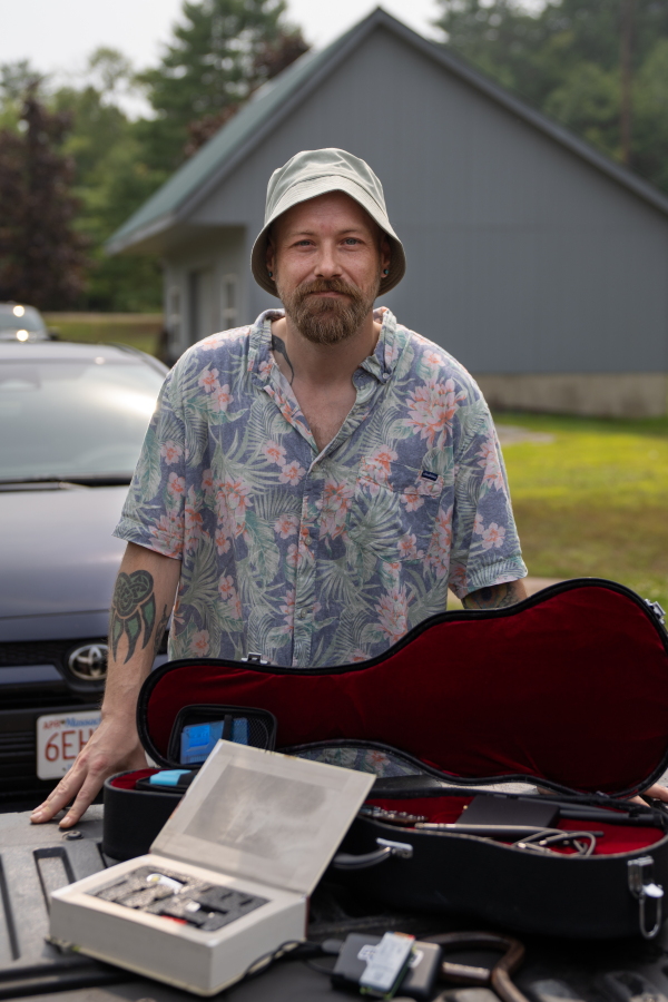 Forest Anderson has been traveling across Vermont doing cybersecurity assessments of different systems. Here he stands with some of the devices he's been able to procure and assemble that have the potential to cause cybersecurity issues.