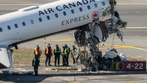 Aircraft maintenance workers inspect the wreckage of an Air Canada Express jet, Tuesday, March 24, 2026, just off the runway where it collided with a Port Authority fire truck Sunday night at LaGuardia Airport in New York. (