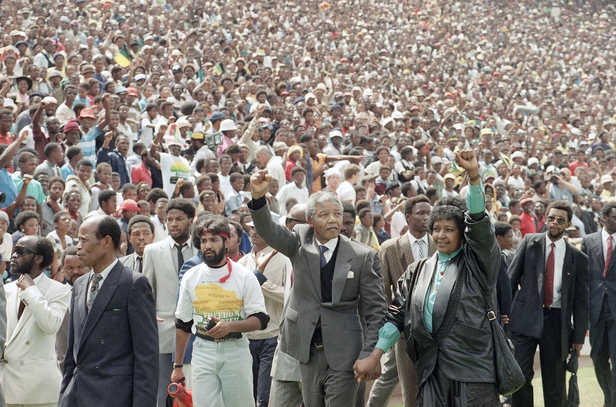 FILE Nelson Mandela and Winnie Mandela give Black power salutes as they enter Soweto's Soccer City stadium, South Africa Tuesday, Feb. 13, 1990. 120,000 thousand people packed the venue to hear his speech.